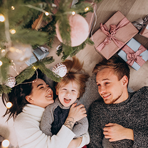 Young family with little son under the Christmas tree